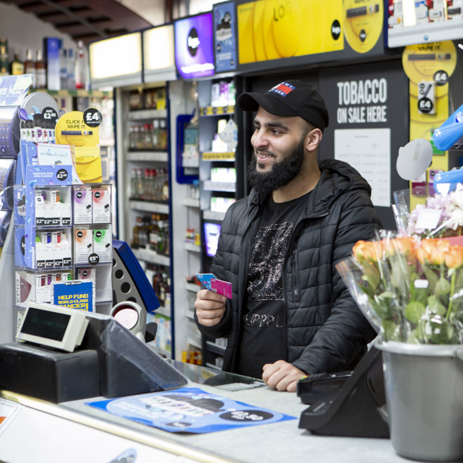 Retailer selling travel payment cards to a customer 
