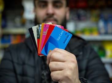 Retailer holding multiple payment cards available via Payzone