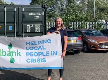 Woman holding sign that says helping local people in crisis