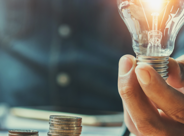 lightbuld held next to coins 