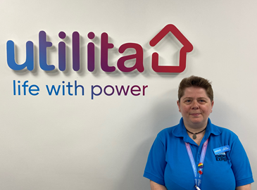 Utilita employee standing in front of Utilita sign