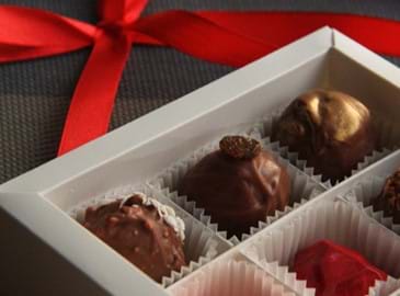 A box of chocolates with a red ribbon